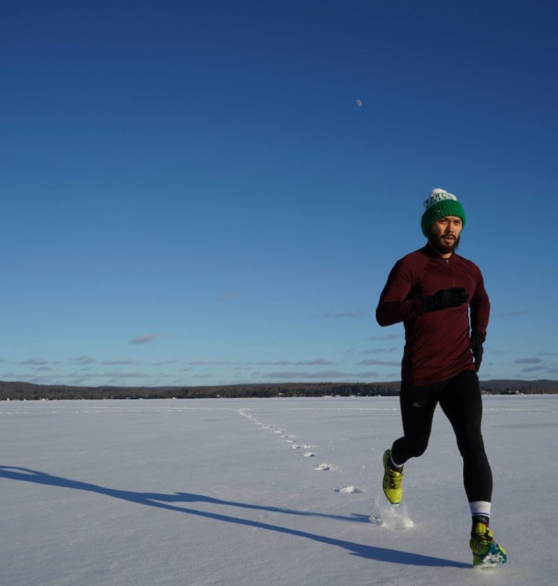 biegacz rozgrzewający się pod czas zimowej słonecznej pogody